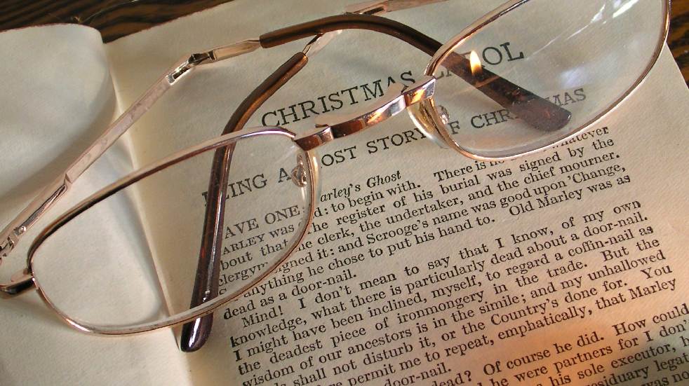 reading glasses on top of a Christmas Carol book